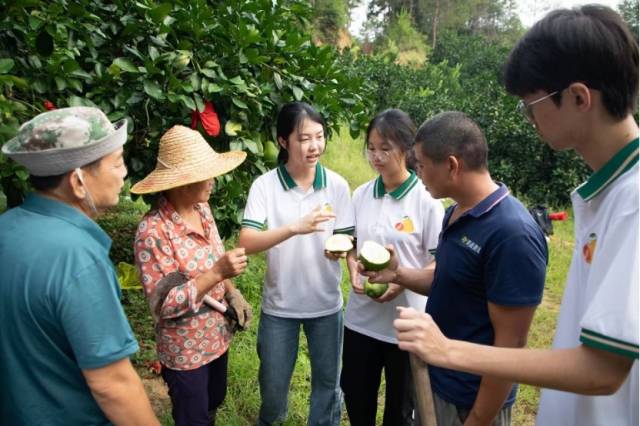 MK平台师生团队向柚农介绍废果的利用价值。